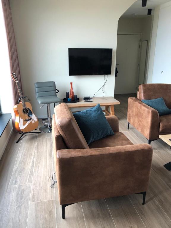 - un salon avec un canapé et une télévision dans l'établissement Residentie Zeezicht, à Eksel