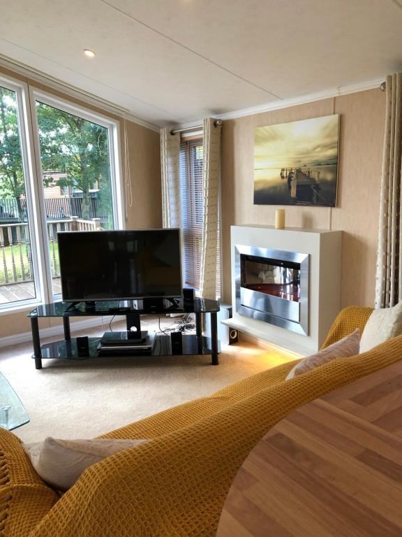 a living room with a television and a fireplace at Gold Caravan in Harrietsfield