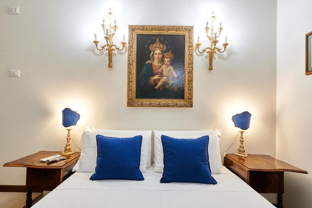 Un dormitorio con una cama con almohadas azules y una pintura en Fabrizio's Rooms en Roma