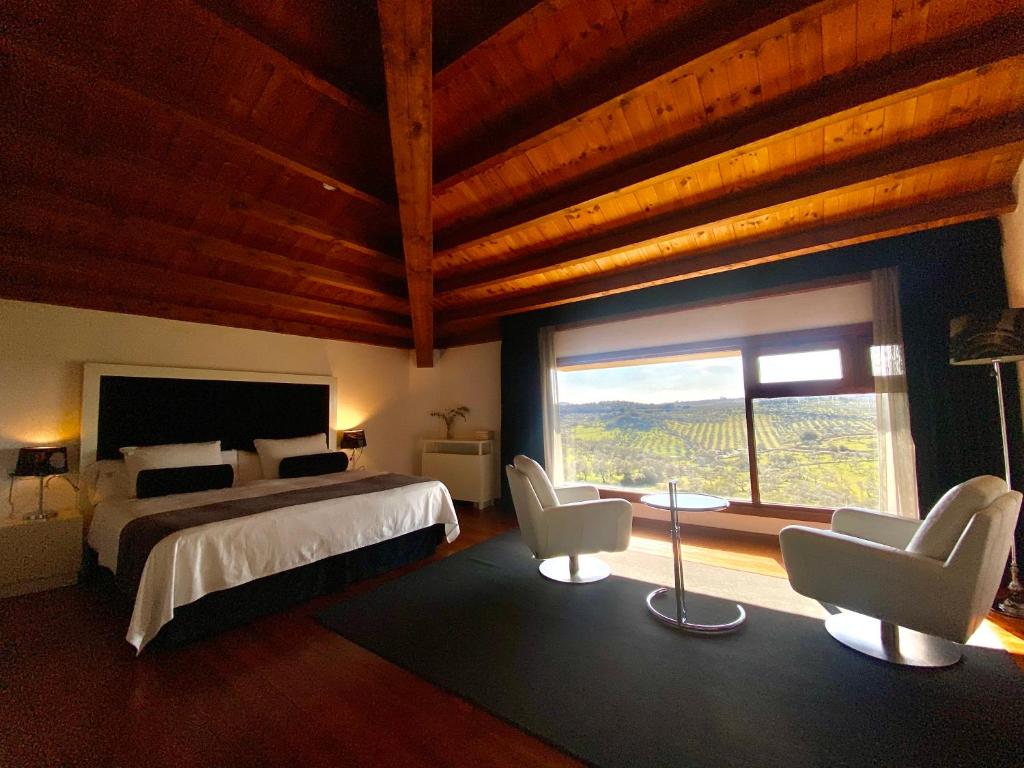 
a hotel room with a bed, chair and a window at Convento San Diego - Singulars Boutique Hotels in Fuentes de León

