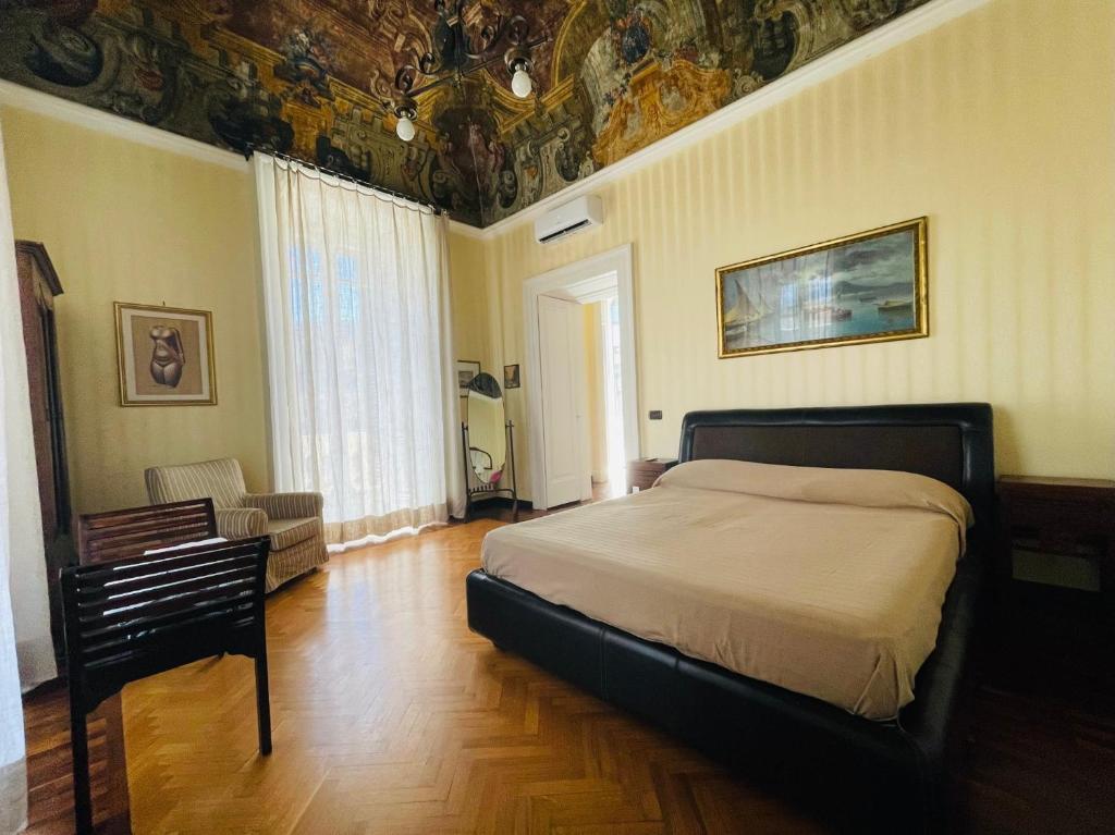 a bedroom with a bed and a ceiling with paintings at Appartamento sul Teatro San Carlo in Naples