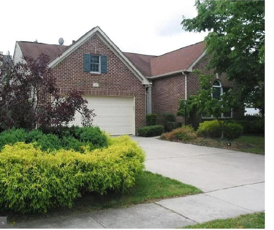 a brick house with a driveway and a garage at Cherry Hill House in Cherry Hill