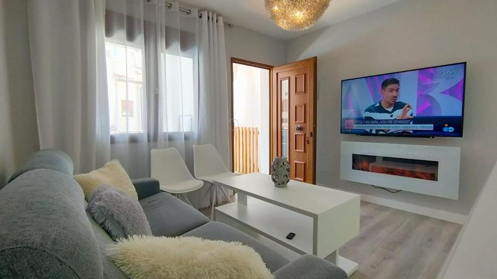 een woonkamer met een bank en een flatscreen-tv bij Suite Ruidera Beach in Ruidera