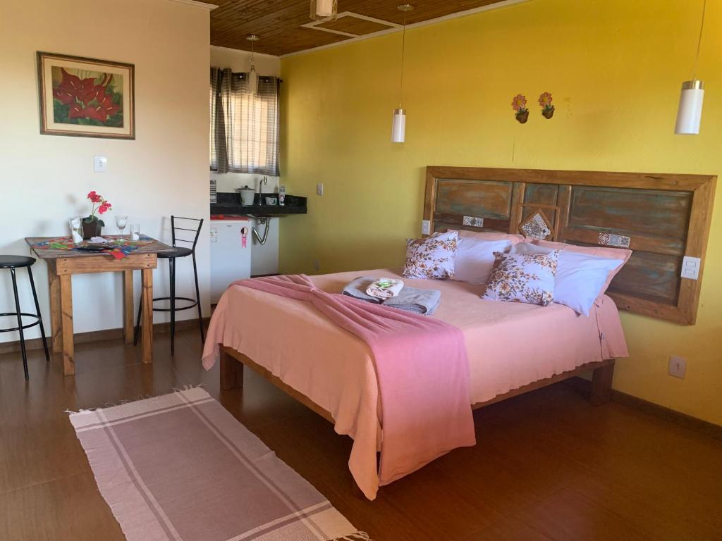 a bedroom with a large pink bed in a room at Pousada Sossego in Lavras Novas