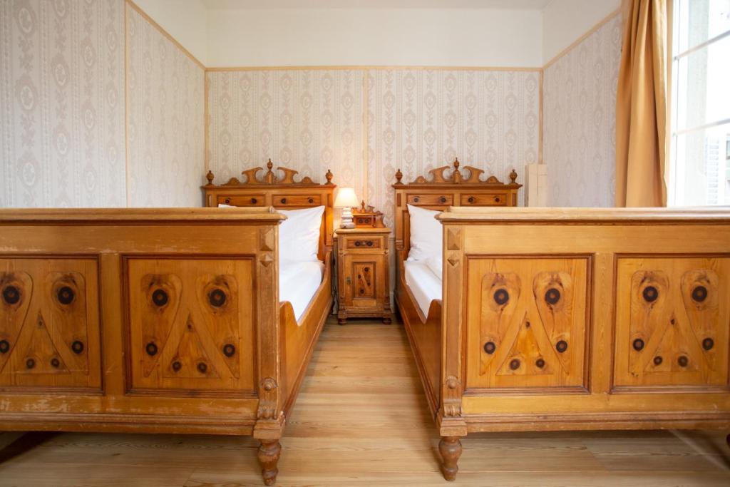 two beds in a bedroom with wooden cabinets at Zunfthaus zur Rebleuten in Chur