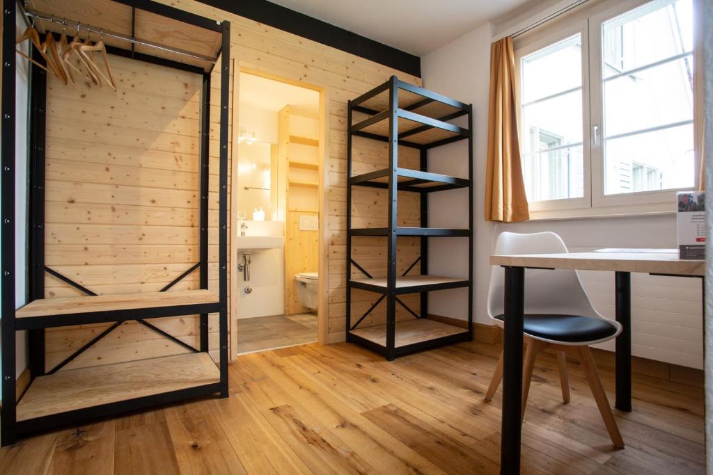 a room with a desk and a room with a closet at Zunfthaus zur Rebleuten in Chur
