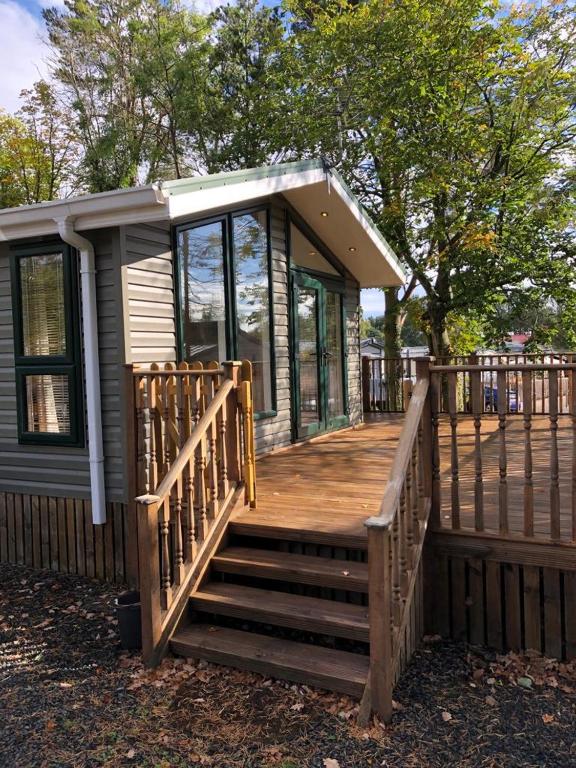 a small house with a large wooden deck at Gold Caravan in Harrietsfield