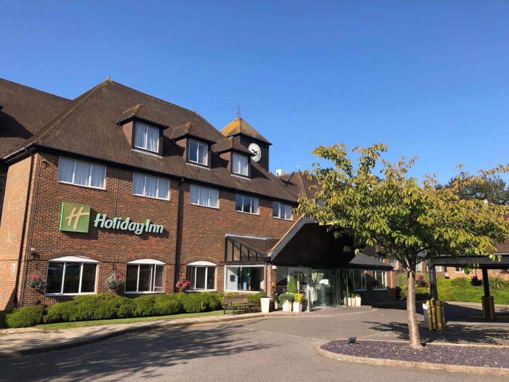 a large red brick building with a clock on it at Holiday Inn Ashford - North A20, an IHG Hotel in Ashford