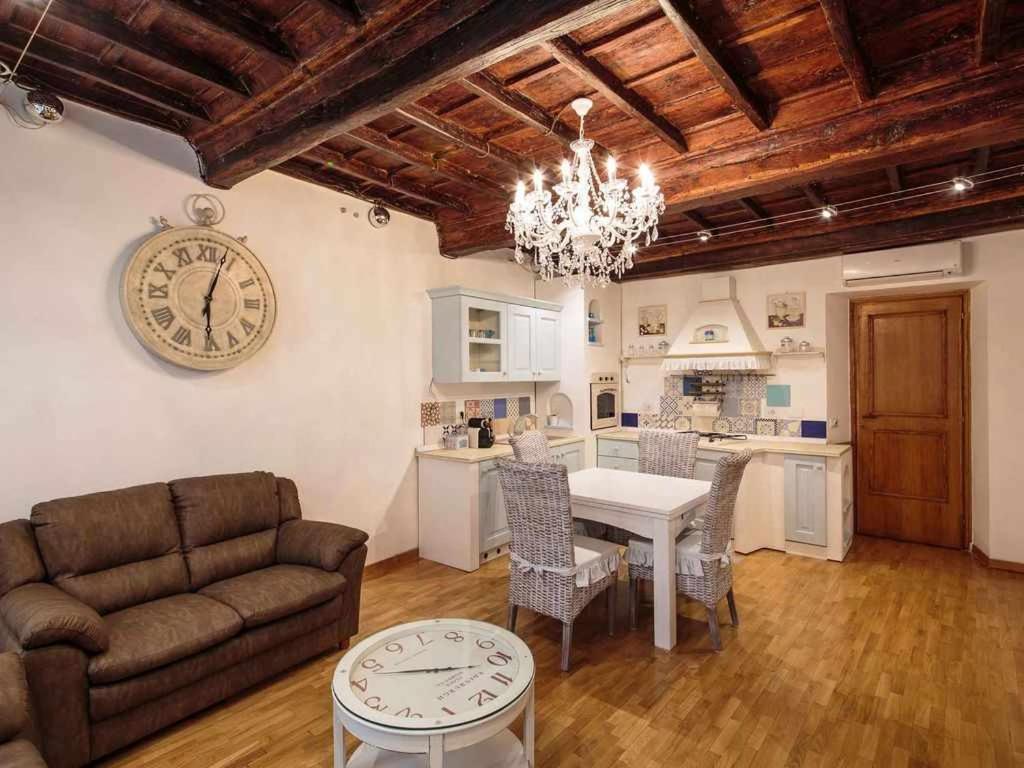 ein Wohnzimmer mit einem Sofa und einer Uhr an der Wand in der Unterkunft Appartamento familiare nel cuore di Roma in Rom