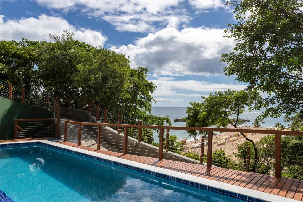 a swimming pool with a view of the ocean at Casa com piscina, deck e vista para o mar in Morro de São Paulo