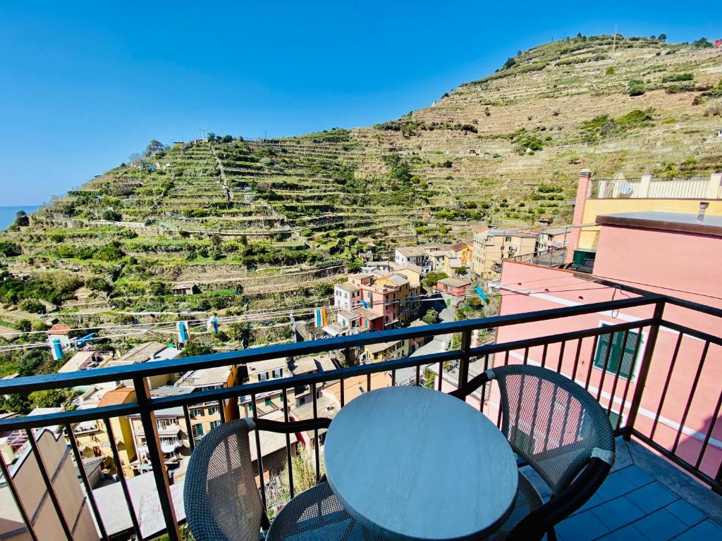 a balcony with a table and chairs and a hill at Giovanni Rooms Manarola in Manarola