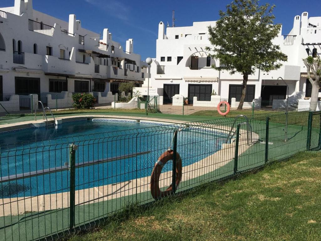 a fence around a swimming pool in front of a building at La Martinica in Agua Amarga