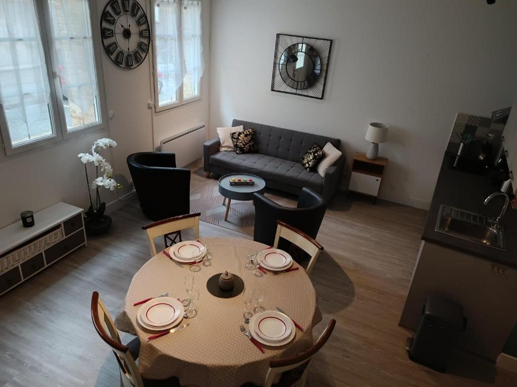 a living room with a table and a couch at Les Fées Mer - Dieppe - Normandie in Dieppe