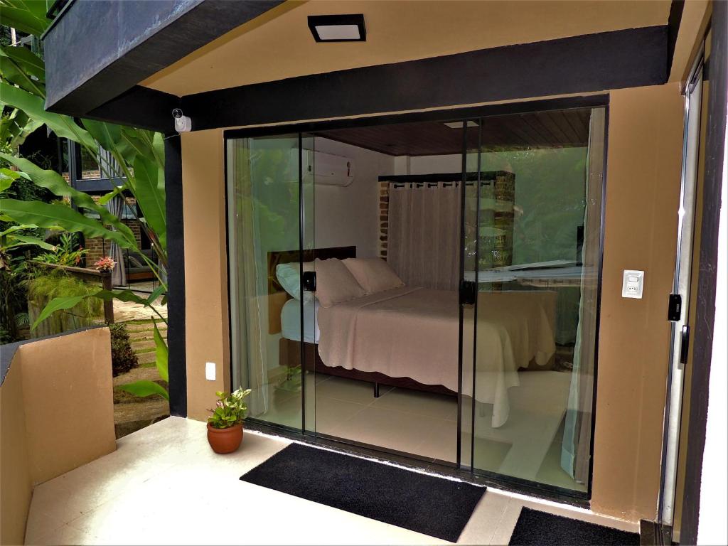 Una habitación de cristal con una cama dentro. en MICROCASA DE PRAIA, en Angra dos Reis