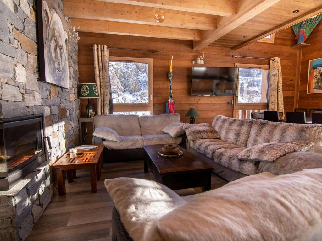a living room with couches and a stone wall at Chalet Valloire, 5 pièces, 12 personnes - FR-1-263-498 in Valloire