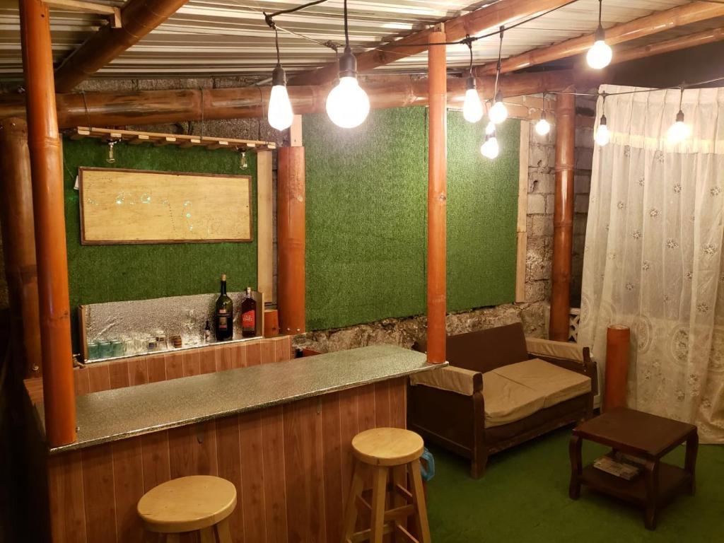 a bar with a green wall and some stools at CASA VIEJA del Centro Historico in Quito