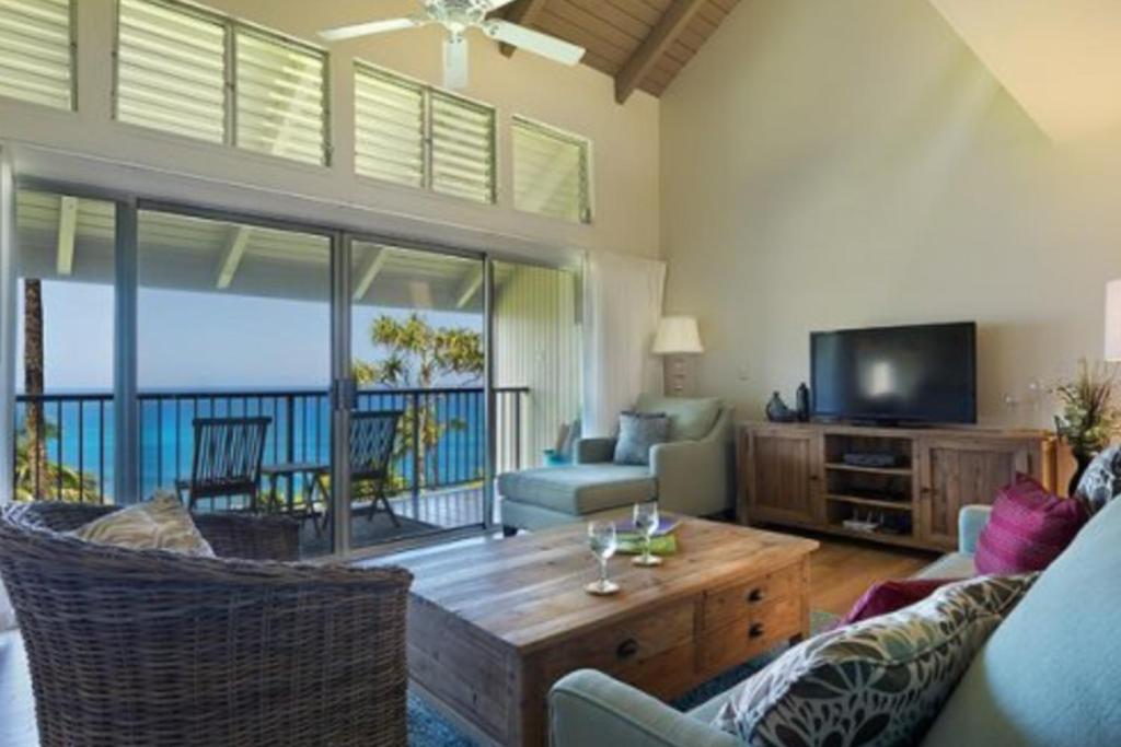 a living room with a couch and a television at Pali Ke Kua 209 in Princeville