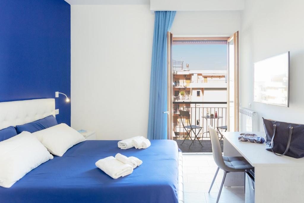 Habitación azul con cama, mesa y balcón. en Le Tre CCC, en Sorrento