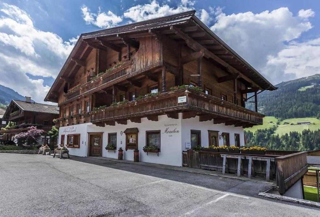 a large wooden building with a balcony at Appartement Moaeben - Panorama in Alpbach