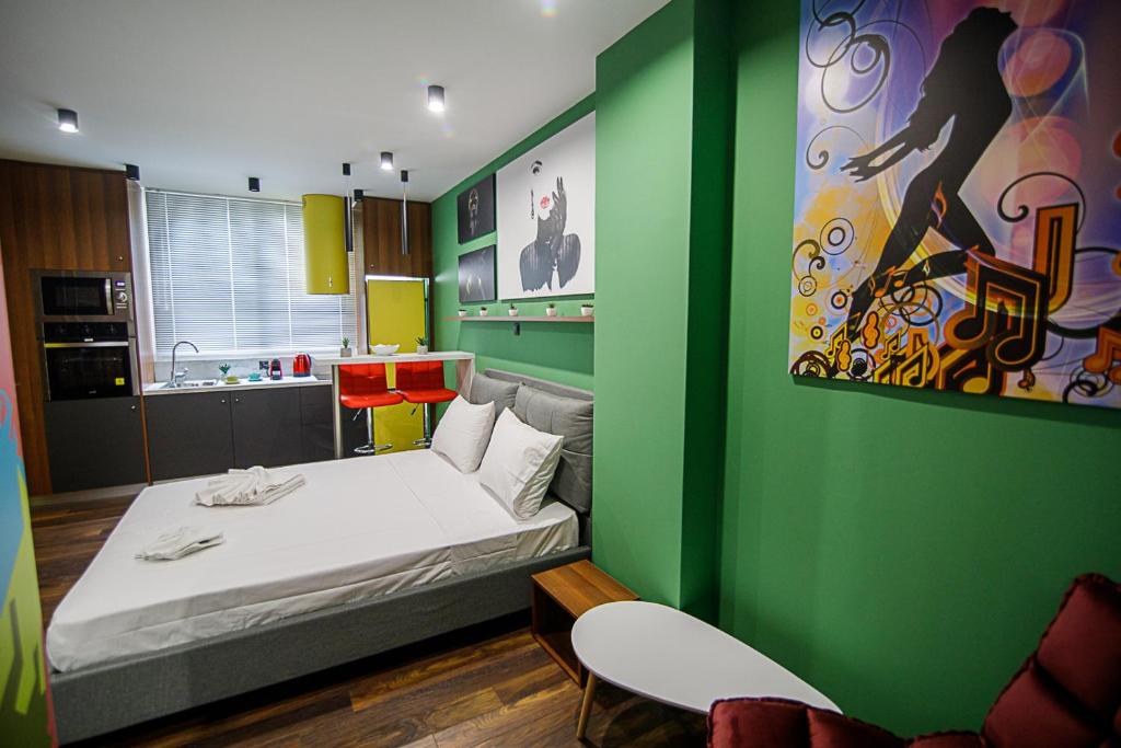1 dormitorio con cama y pared verde en Facadoro Apartments, en Atenas