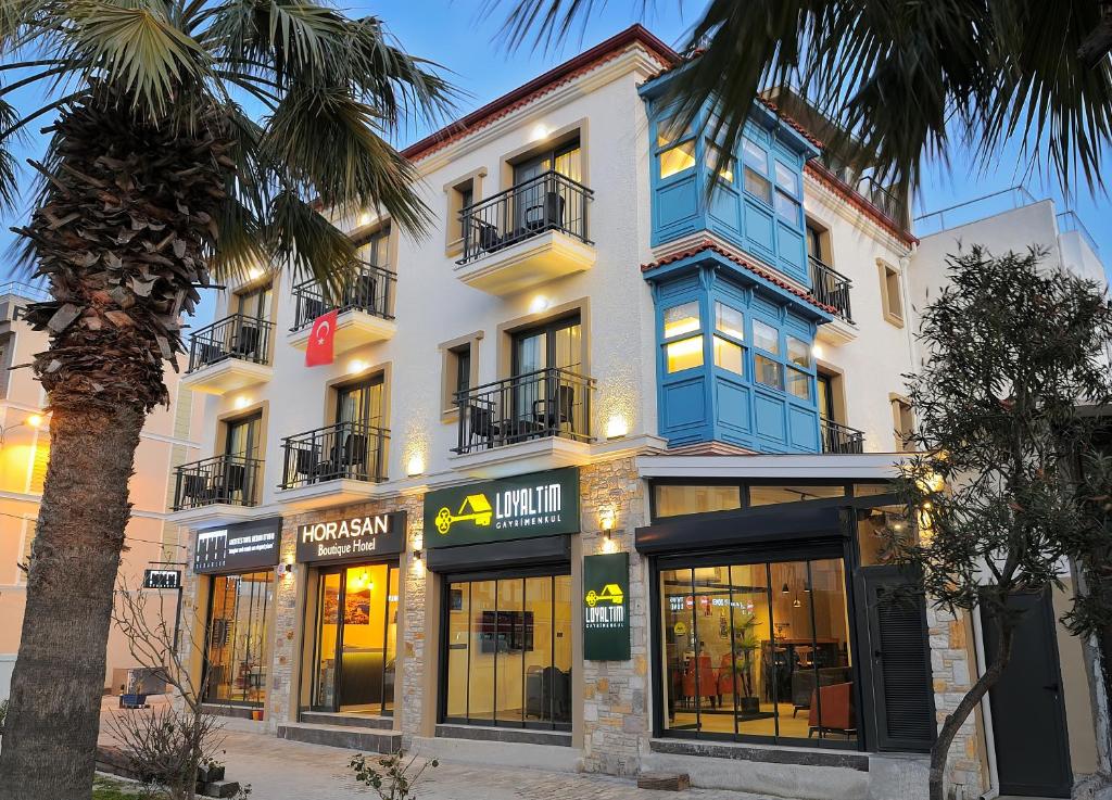 um edifício com uma palmeira em frente em Horasan Boutique Hotel em Cesme
