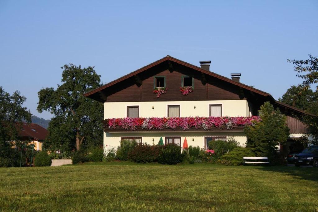 ein Haus mit Blumen auf der Seite in der Unterkunft Ferienwohnungen Grabnerbauer in Mondsee