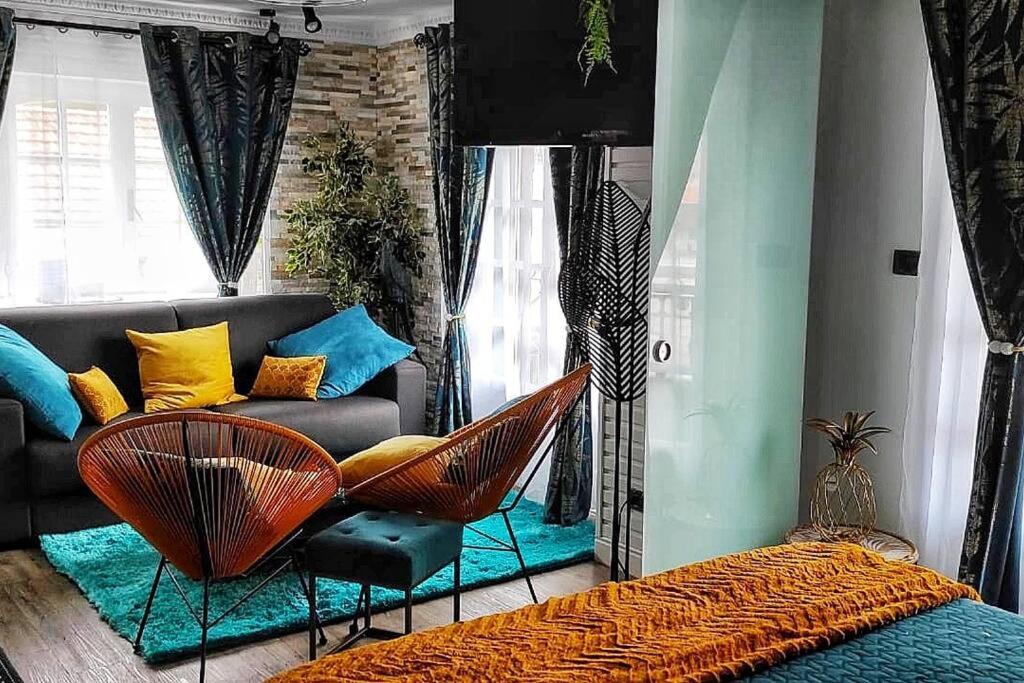 sala de estar con sofá y sillas de mimbre en Hoja de Arce - Apartamento Rural, en Castro Urdiales