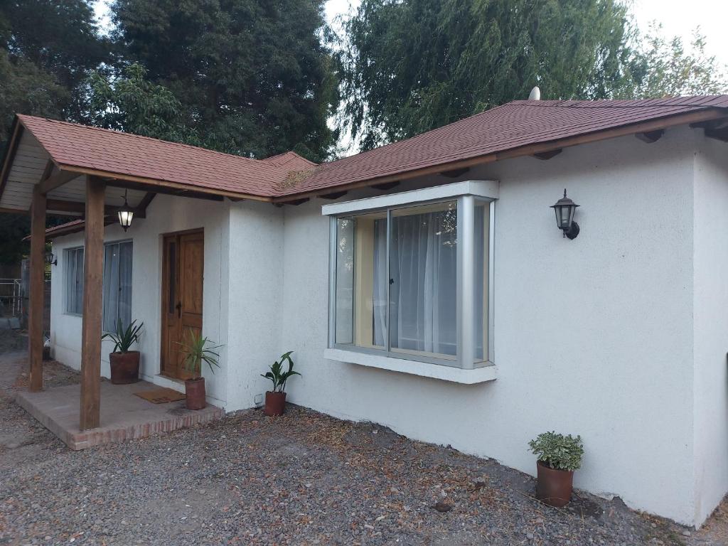 a white house with a window and potted plants at Hostal Casa Encino in Santa Cruz