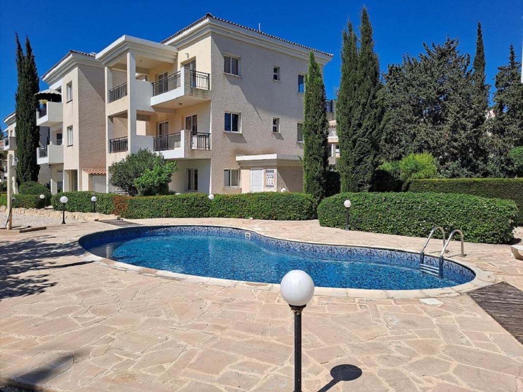 een gebouw met een zwembad voor een gebouw bij The well-equipped luxury apartment Paphos Riviera in Paphos City
