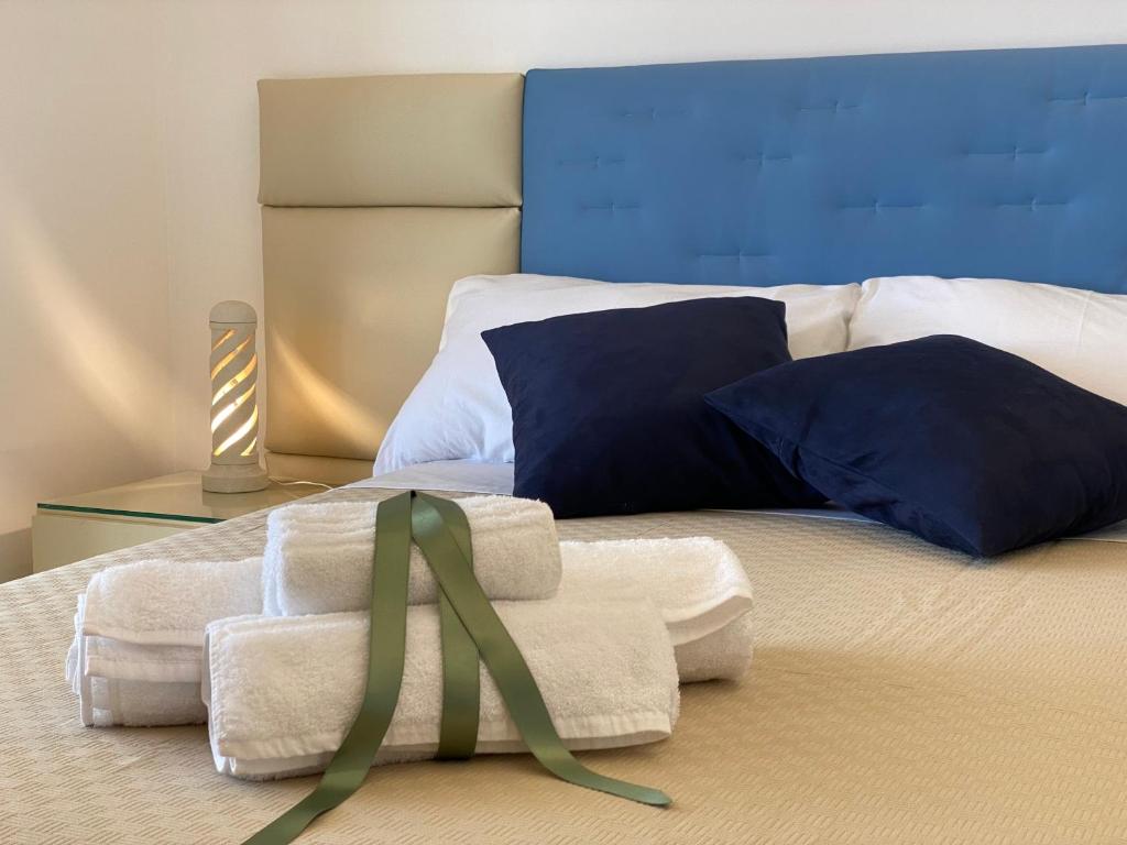 ein Schlafzimmer mit einem Bett mit Handtüchern und einem Band darauf in der Unterkunft Salento Prestige B&B in Martano