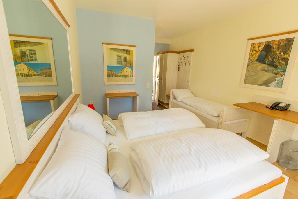 Zimmer mit 3 weißen Betten in der Unterkunft Hotel Elia in Guntramsdorf