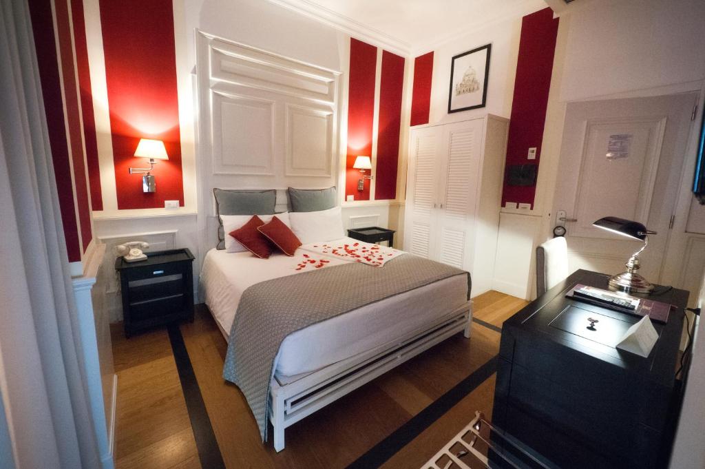 una camera con un letto bianco e pareti rosse di Hotel Bologna ***S a Verona