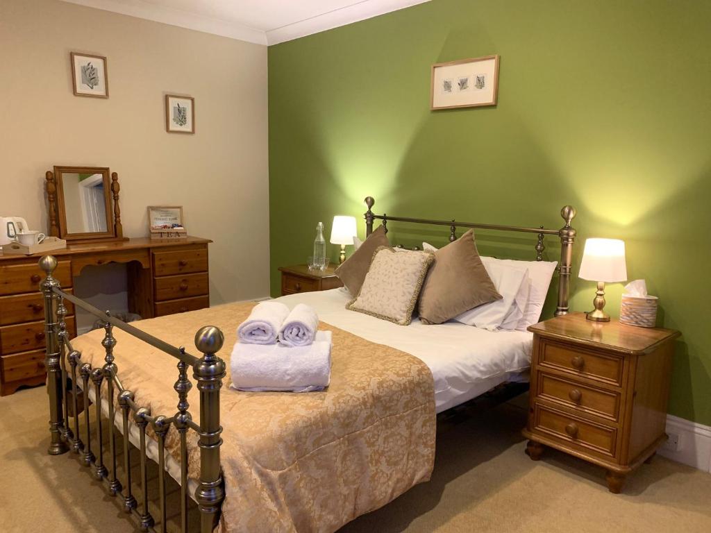 a bedroom with a bed with two towels on it at Dolphin Hotel in Bovey Tracey