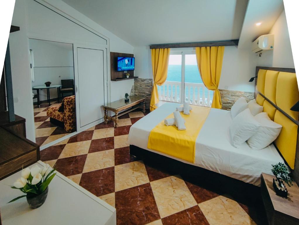 a hotel room with a bed and a view of the ocean at Sun Apartments in Ulcinj