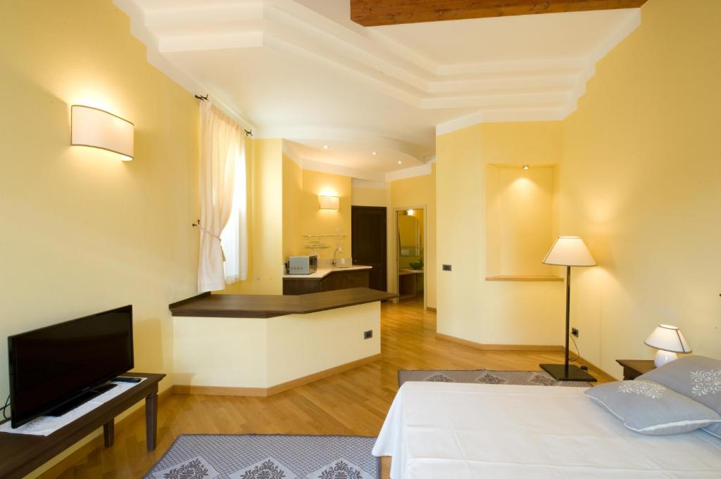 ein Hotelzimmer mit einem Bett und einem Fernseher in der Unterkunft Piazza Azuni 18 Guest House in Sassari