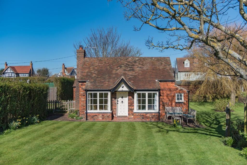 a red brick house with a grass yard at The Nest by Bloom Stays in Dymchurch