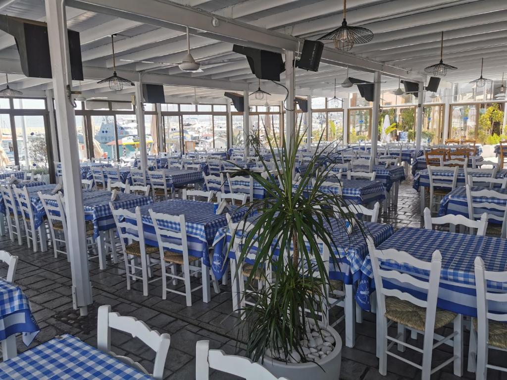 un ristorante con tavoli e sedie blu e bianchi di Y & P LATCHI HOTEL a Lachi