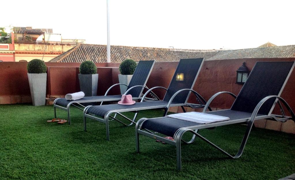 uma fila de cadeiras sentadas na relva num telhado em Life Apartments Quintana em Sevilha