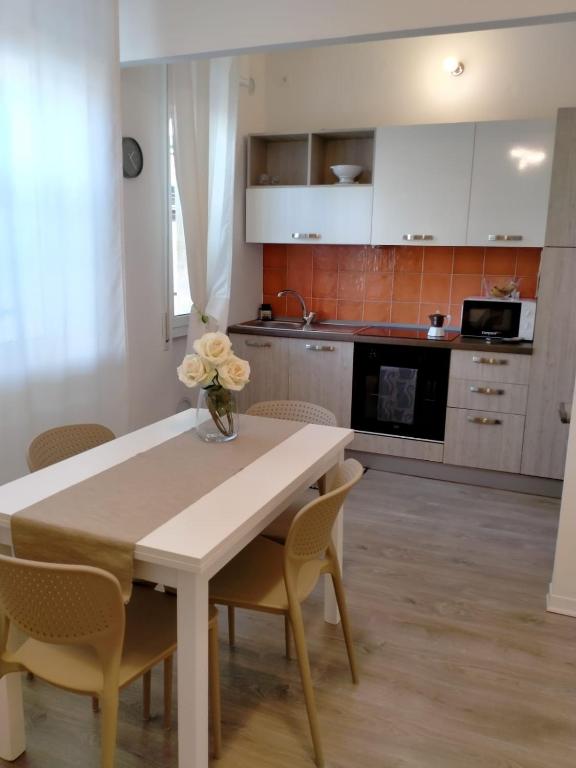 a kitchen with a table with a vase of flowers on it at Sea&Bike_Apartment in Finale Ligure