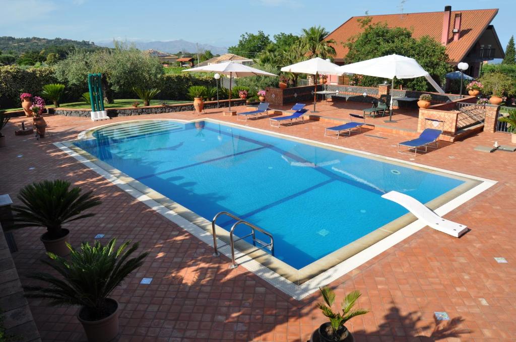 a large swimming pool in a brick yard at Villa del Sole in Zafferana Etnea