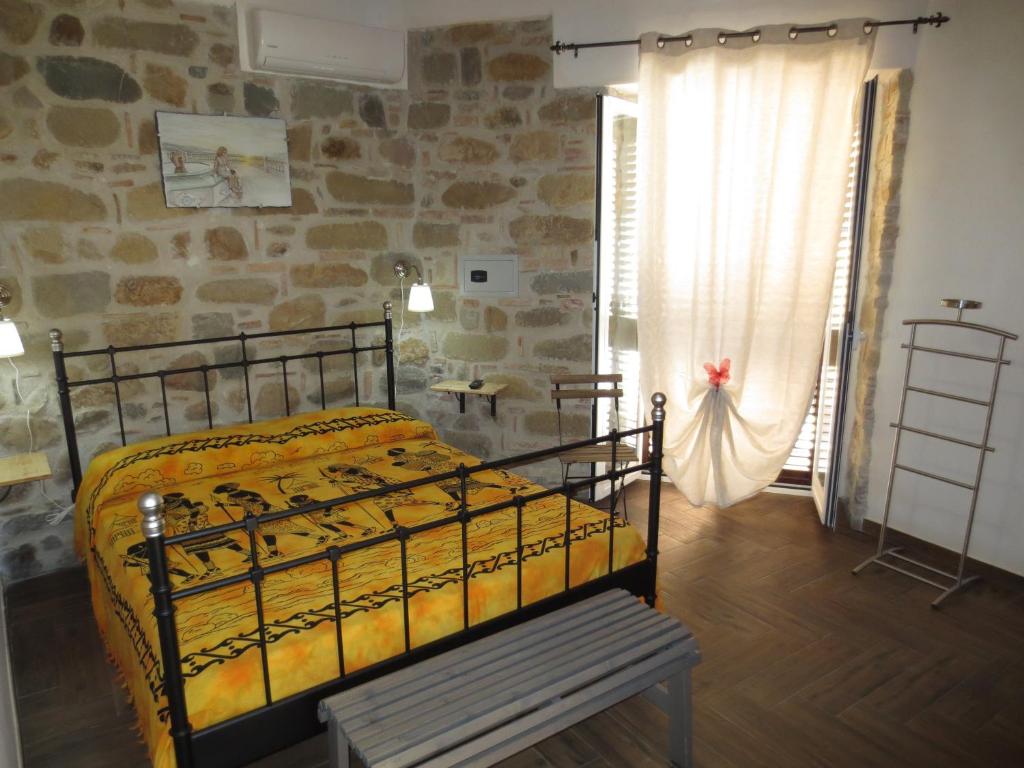 a bedroom with a bed and a stone wall at Aurora Bed and Breakfast in Santo Stefano di Camastra