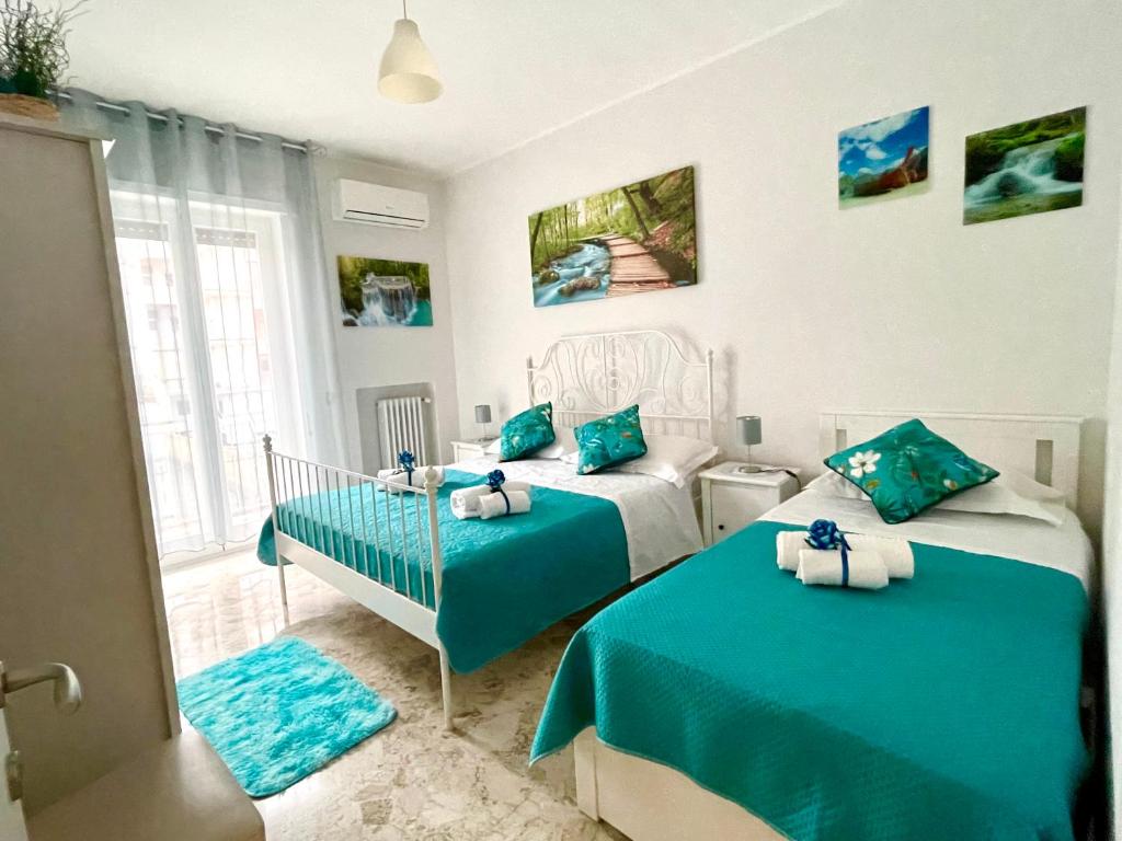 a bedroom with two beds with blue sheets at Apartment Savoia in Bari