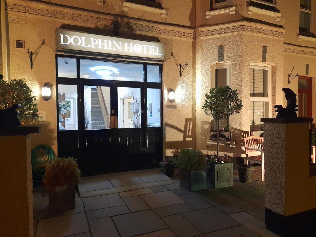 エクスマウスにあるThe Dolphin Hotel Exmouthのイルカホテルの看板を持つ店頭