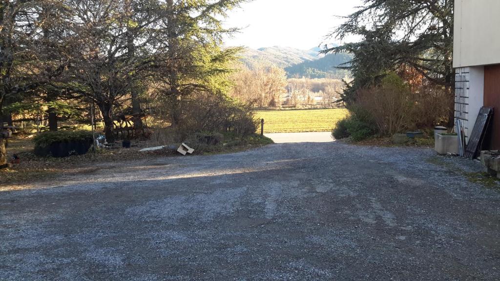 une allée vide à côté d'une maison arborée dans l'établissement Appartement à la campagne, à Aiglun