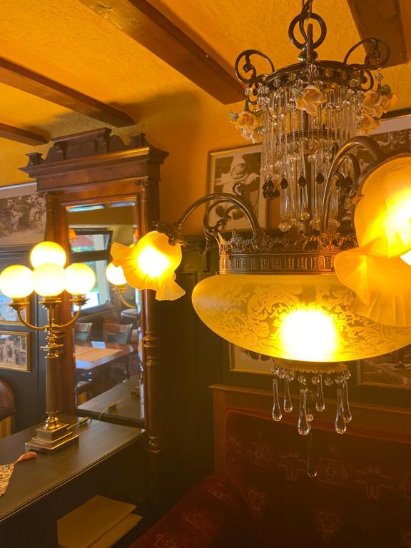 una lámpara de araña colgando en una habitación con luces en Hotel Anker en Kamp-Bornhofen