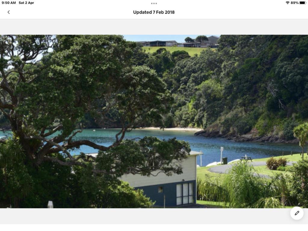 una vista di una casa con spiaggia e acqua di PACIFIC PARADISE COTTAGE a Tutukaka