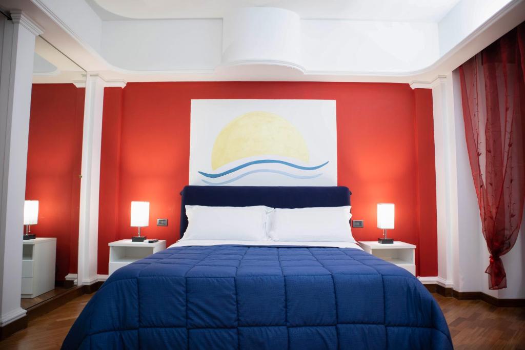 a bedroom with a blue bed with a red wall at B&B Amalfi Coast Salerno in Salerno