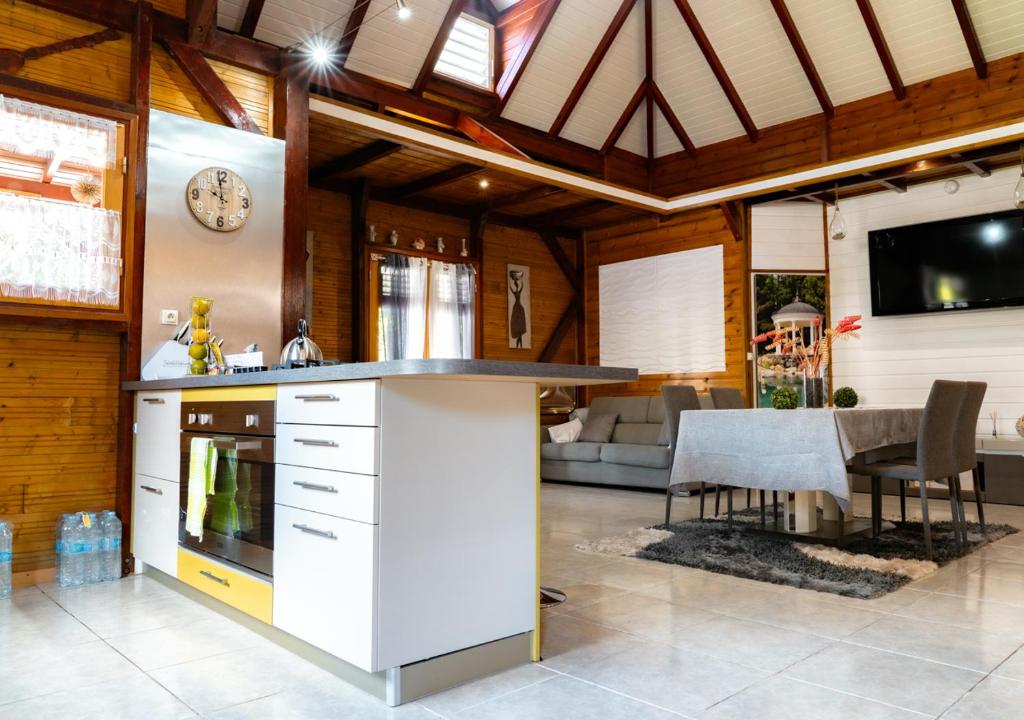 een keuken en een woonkamer met een klok aan de muur bij La Savannah Villa in Labuthie