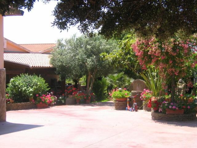 un jardín de flores y plantas en un patio en Agriturismo Gavina Pes, en Campanedda