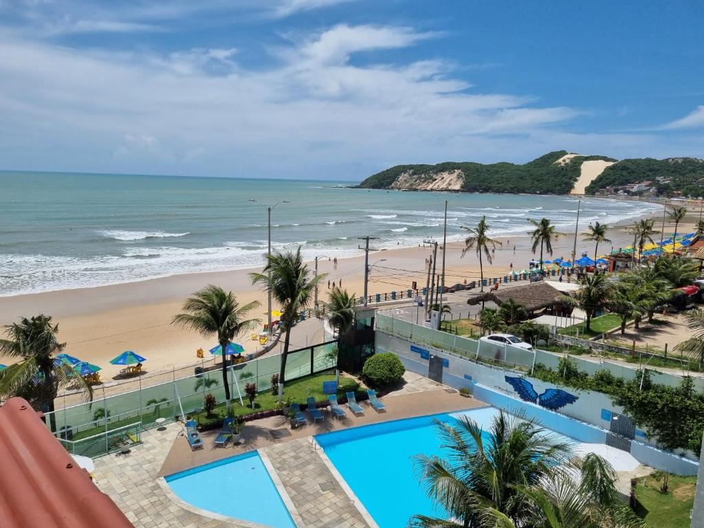a view of the beach from the balcony of a resort at Hotel Ponta Negra Beach by Oxequealuguel in Natal